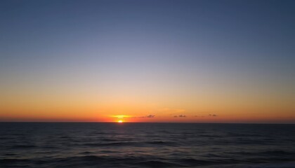 Fototapeta premium Orange sunset paints the evening sea, reflecting light on gentle waves