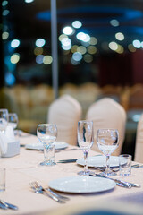 Empty wine glass and cutlery on a table in a restaurant