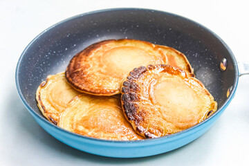 some pancakes in a frying pan, isolated on a white background