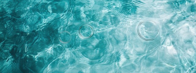 Obraz premium Clear turquoise water with bubbles rising to the surface during a sunny day in a serene setting