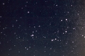 Obraz premium A night sky filled with numerous white dots, resembling stars or snowflakes