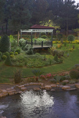Relaxing garden oasis with gazebo and flowing water during twilight