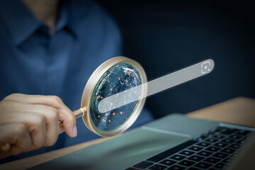 Businessmen holding magnifying glasses show globes and search bar engine icons, which represent...