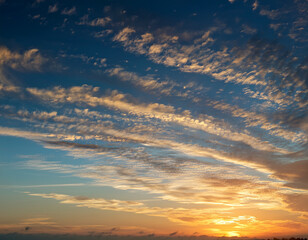 Fototapeta premium A morning sky brushed by golden sunlight shining through thin layers of high-altitude cirrostratus clouds.