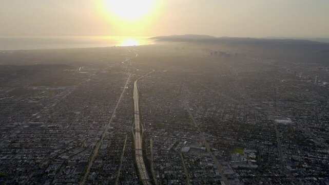 Aerial view of the Sun Reflecting off the Pacific Ocean in Los Angeles with 10 freeway in the foreground and Century City and Santa Monica in the background