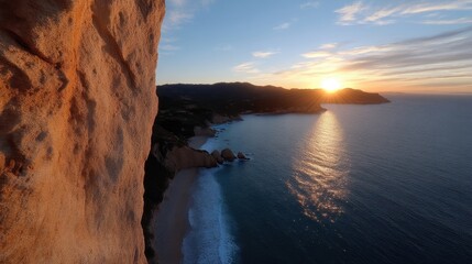 Cliffside sunset over coastal scenery.  Rocky outcrop overlooks a beautiful beach and ocean at golden hour