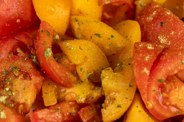 sliced ripe tomatoes of red and yellow color during salad preparation