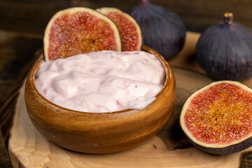 wooden bowl with fresh yogurt with ripe fresh figs