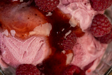 red raspberry ice cream in a glass bowl with raspberry jam