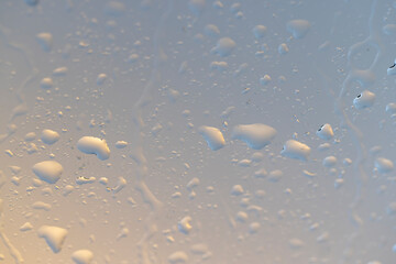 wet glass in cloudy weather, part of the glass from the window in water droplets during a light rain