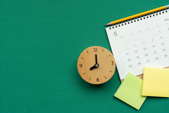 close up of calendar and clock on the green table background, planning for business meeting or travel planning concept