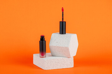 Mockup of black blank thin tube - mascara, lip gloss, gel, eyeliner, oil, etc. Cosmetic package with stylish props on orange background.