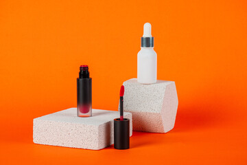 Mockup of black blank thin tube - mascara, lip gloss, gel, eyeliner, oil, etc. Cosmetic package with stylish props on orange background.