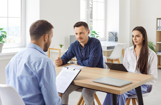 Professional interview, lawyer or financial advisor consulting clients in modern office, interested customers meeting realtor, broker bank worker, discussing agreement or deal, communication solution