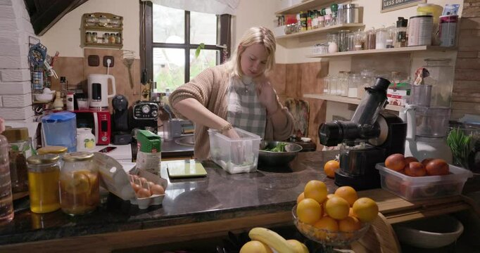A young woman is blending a wild bear garlic in a kitchen