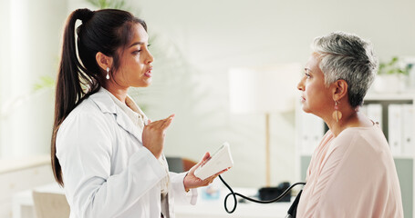 Fototapeta premium Consultation, blood pressure and doctor with mature woman at hospital or clinic for healthcare. Discussion, exam and patient with medical professional for check up for heart health, advice and care