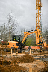 Excavator and crane in action on a subdivision construction site.