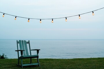 Fototapeta premium Cozy Outdoor Scene with Rocking Chair and String Lights by Water