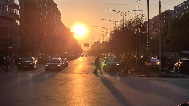 Sun setting over Iuliu Maniu Boulevard in Bucharest with traffic and long shadows