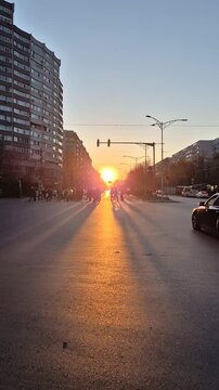 Sun setting over Iuliu Maniu Boulevard in Bucharest with traffic and long shadows