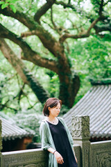Fototapeta premium A Chinese woman traveling at a temple on Putuo Mountain in Ningbo, Zhejiang, China, during summer season