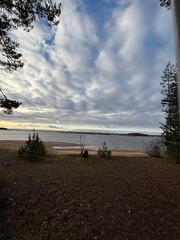 a beach on the shore of a cold lake in cloudy weather in autumn