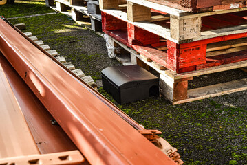 Black rodent bait and trap station being used outside a building to control rats.