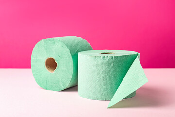 Green toilet paper rolls on pink background