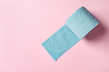 Blue toilet paper roll on light pink background, top view. Space for text