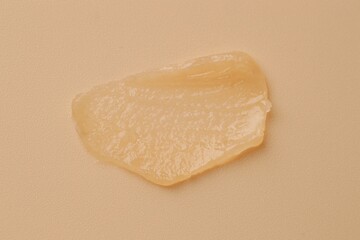 Moisturizing lip balm on beige background, top view