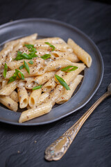 Penne with ground pepper and Gorgonzola creamy sauce, sprinkle with chopped chives.
