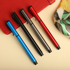 Elegant Pen Standing on Open Notebook with Vivid Decorative Backdrop, concept idea photo. Study desk image, top view.