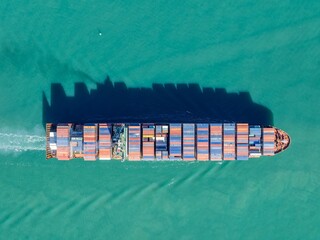 Aerial view of a cargo ship transporting shipping containers across the ocean. The vessel is moving goods for international trade and commerce. , AUCKLAND, NZ