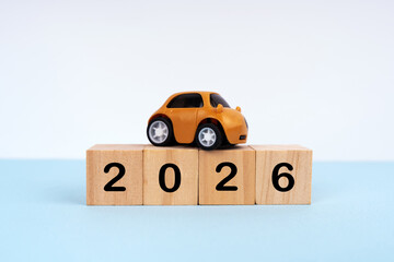2026 written on wood blocks with mini car model. New Year plan concept