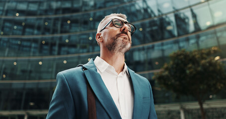 Banker, thinking or businessman in city with building, ambition and financial opportunity. Travel, finance advisor or mature investment broker in low angle for commute, vision or ideas in England © peopleimages.com