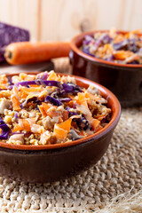 Colorful vegan cous cous with chickpeas, purple cabbage and carrots. Topping of tahini and flax seeds.