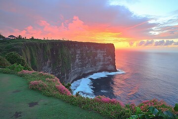  A serene cliffside overlooking the ocean, with a vibrant sunset casting orange and pink hues over the water, as waves crash below. 