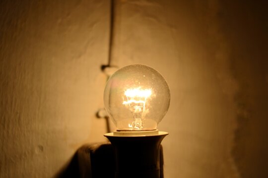 An incandescent light bulb in a dark room