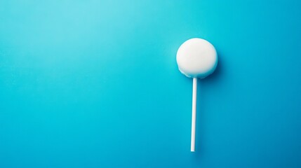 Isolated white lollipop on blue background sweet candy treat dessert confectionery sugar snack minimal design