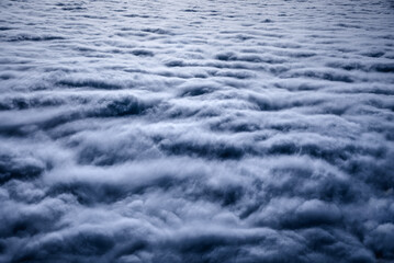 Dramatic moody dark gray cloudy sky. Seamless clouds from above. Flying over the storm clouds. Overcast sky seen from an airplane. Rain cloudscape.