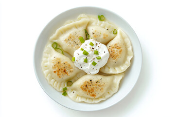 a white plate topped with dumplings and a dollop of sour cream