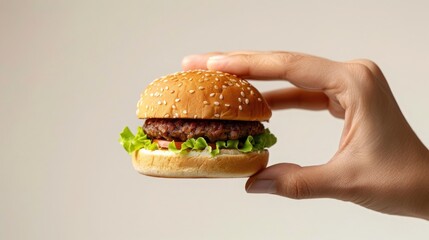 Delicious Mini Burger in Hand, Close up of a hand holding a small, appetizing burger.