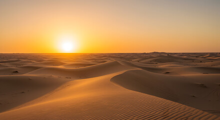 Tranquil expanse of sand dunes under a vibrant sunset glow in the desert