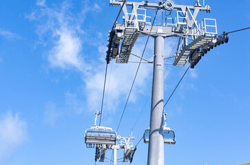 Ski lift under blue sky on a sunny day. Copy space.