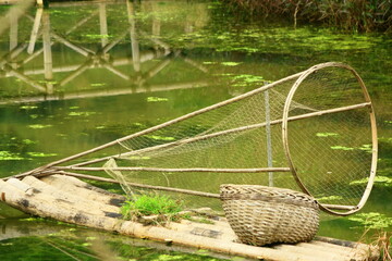 Old fishing net draped over an aged bamboo raft in rural Asia.