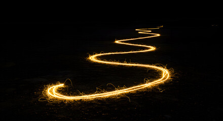 Glowing trails serpentine light painting on dark ground, an abstract design concept