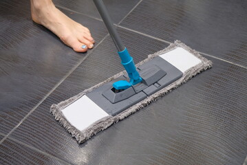 man cleaning floor with mop