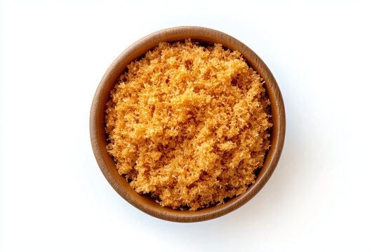 a bowl of brown sugar on a white surface