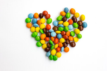 A pile of colorful chocolate candies arranged in the shape of a heart.