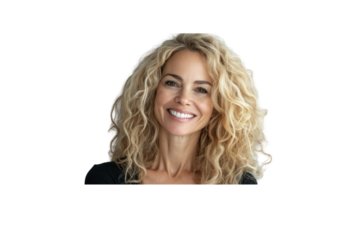 A cheerful blonde woman with voluminous curly hair, radiating warmth and joy, smiling against a soft gray background. Her natural beauty shines through as she gazes into the camera